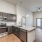 Spacious and well lit kitchen with wood flooring and stainless steel appliances